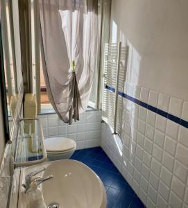 a bathroom with a sink and a toilet and a window at Appartamento in centro：Montecatini Terme in Montecatini Terme