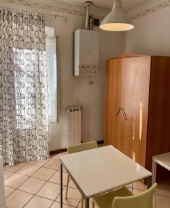 una sala da pranzo con tavolo, sedie e finestra di Appartamento in centro：Montecatini Terme a Montecatini Terme
