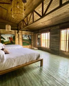 1 dormitorio con 1 cama grande en una habitación de madera en Ankua Eco Hotel, en Usiacurí