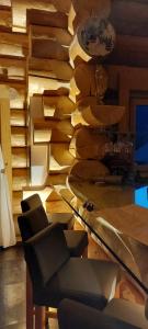 - un salon avec une table, des chaises et un mur dans l'établissement Chalet Anzac Chalet 5 Etoiles en Rondins Tout Neuf Unique dans les Aravis, à Les Villards-sur-Thônes