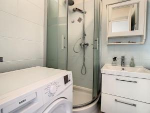 a bathroom with a shower and a washing machine at Appart Crystal Lyon Caluire et parkings in Caluire-et-Cuire
