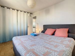 um quarto com uma cama grande e almofadas vermelhas em Appart Crystal Lyon Caluire et parkings em Caluire-et-Cuire