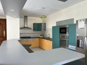 a kitchen with a white counter top and green cabinets at Appartements - Le Paradisier Ambatobe in Antananarivo