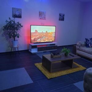 sala de estar con TV de pantalla plana y sofá en ORCHID House Stylish 3BDR Terrace Duplex Free WiFi DSTV en Lekki