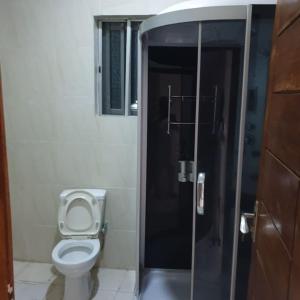ein Badezimmer mit Toilette und Glastür in der Unterkunft ORCHID House , Orchid Road , Lekki , Stylish 3BDR Terrace Duplex Free WiFi DSTV in Lekki + 83 Fotos