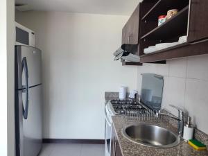 cocina con fregadero y nevera en Confort suite whit view, en Quito