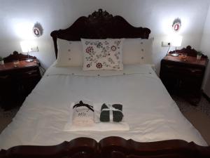 a bedroom with a large bed with two bags on it at The Jasmine House in Olvera