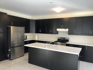 uma cozinha com armários pretos e um frigorífico de aço inoxidável em 537 Veterans Dr Brampton ON L7A 5A6 em Brampton