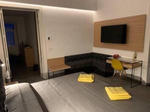 a bedroom with a bed and a desk and a television at SUITE Nobile in Catania