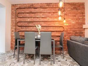 comedor con pared de ladrillo, mesa y sillas en Haven en Lytham St Annes