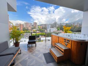 a hot tub on a balcony with a view of a city at Haven A Design Hotel in Medellín