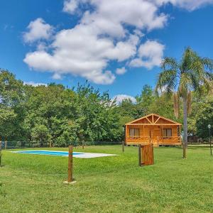 una cabaña en un campo con una piscina y un árbol en Cielito Lindo Cabañas en Gualeguay