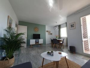 a living room with a white table and a tv at Casa Alegria - Laguna Beach in Torrox Costa