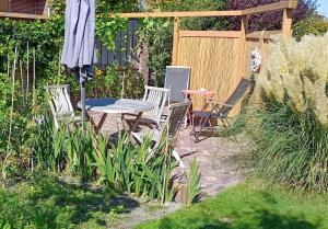 a patio with a table and chairs and an umbrella at Zee&Meer in Julianadorp