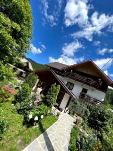 a house with a garden in front of it at Pensiunea Bradet in Broşteni