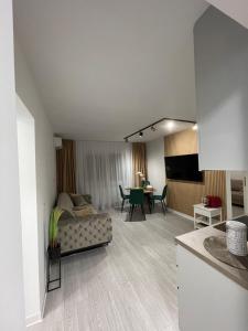 een woonkamer met een bank en een eetkamer bij Oxana Apartments - 3 camere - Timisoara in Timişoara