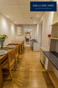 uma cozinha e sala de jantar com mesas e cadeiras de madeira em Dwellcome Home Ltd Spacious 8 Ensuite Bedroom Townhouse - see our site for assurance em South Shields
