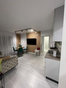 een keuken en een woonkamer met een bank en een tafel bij Oxana Apartments - 3 camere - Timisoara in Timişoara