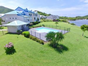 una vista aérea de un patio trasero con piscina en Le Baileys - Spacieux appartement en rez-de-jardin vue lagon, en Marigot