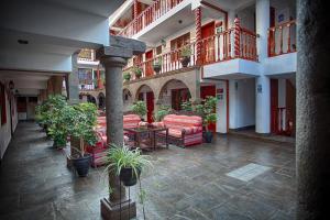 a courtyard with couches and potted plants in a building at Munay Wasi Inn in Cusco