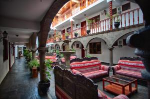 a room with couches and tables in a building at Munay Wasi Inn in Cusco