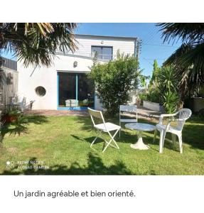 ein Haus mit einem Tisch und Stühlen im Hof in der Unterkunft A quelques pas du moulin blanc in Brest