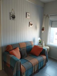 a living room with a couch with pillows on it at De Boa na Lagoa in São Lourenço do Sul