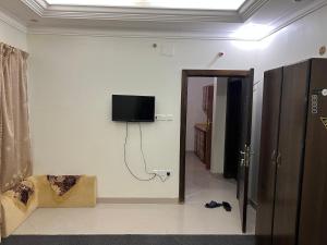 a room with a tv on the wall and a door at هدى الحجاز للشقق المفروشة in Mecca