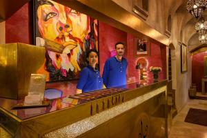 Un uomo e una donna in piedi dietro un bancone in un ristorante di Riad Wow a Marrakech Altre 37 foto