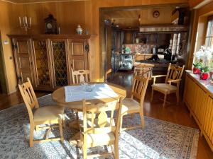 Feusdorf的住宿－Ferienhaus Eifelblick，一间带木桌和椅子的用餐室