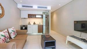 a living room with a couch and a kitchen at Zimbali Suite 217 in Ballito
