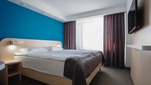 a hotel room with a bed with a blue wall at Park Hotel in Tiraspol