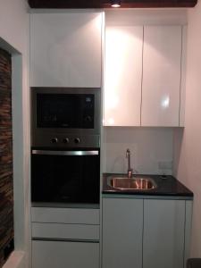 a kitchen with a sink and a microwave at Casa da Muralha Suíte in Monsaraz