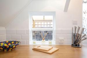 una cucina con tavolo in legno e finestra di 3 Bed House/Garden/Wi-Fi/Parking/Central Location a Stoughton