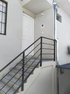 una escalera en un edificio blanco con una barandilla negra en LA FLOR AZUL en Alta Gracia