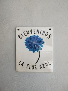 un cartel con una flor azul en la pared en LA FLOR AZUL en Alta Gracia