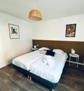 ein Schlafzimmer mit einem großen Bett mit weißer Bettwäsche und Kissen in der Unterkunft Au perron avec garage et balcon à Ribeauville in Ribeauvillé