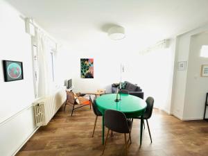 een woonkamer met een groene tafel en stoelen bij Au perron avec garage et balcon à Ribeauville in Ribeauvillé +11 foto's