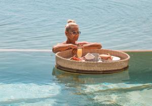 a woman in the water in a boat in the water at Khaban Bacalar Hotel Boutique in Bacalar
