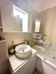 a white bathroom with a sink and a tub at Penthouse one bedroom with a view of Zagreb in Zagreb