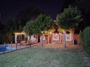 una casa con piscina por la noche con luces en Quinta El Cholito en Luján