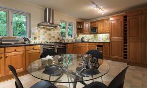 a kitchen with a glass table and some chairs at Merewood Lodge in Ambleside