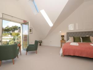 a white bedroom with a bed and a window at 4 Court Terrace, Hillfield Village in Dartmouth