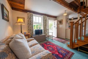 ein Wohnzimmer mit einem Sofa und einem TV in der Unterkunft Lifeboat Cottage by Big Skies Cottages in Brancaster