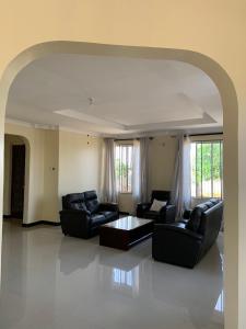 Sala de estar con 2 sofás y mesa en Dodoma, Tukae Inn en Dodoma