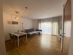 a living room with a couch and a table at APARTAMENTO EN CENTRO PUEBLO in Ribes de Freser