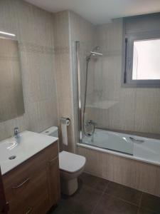 y baño con aseo, ducha y lavamanos. en APARTAMENTO EN CENTRO PUEBLO, en Ribes de Freser