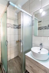 a bathroom with a sink and a glass shower at Alternative Plan in Ierapetra