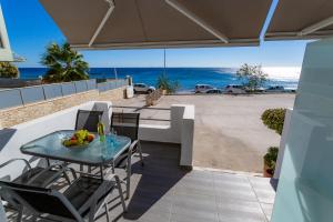 a table and chairs on a balcony with a view of the ocean at Alternative Plan in Ierápetra