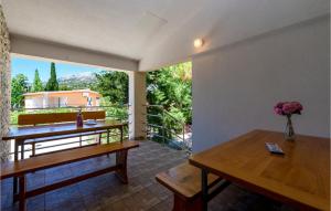 Habitación con mesas de madera y ventana grande. en Awesome Home In Starigrad With House Sea View, en Starigrad-Paklenica